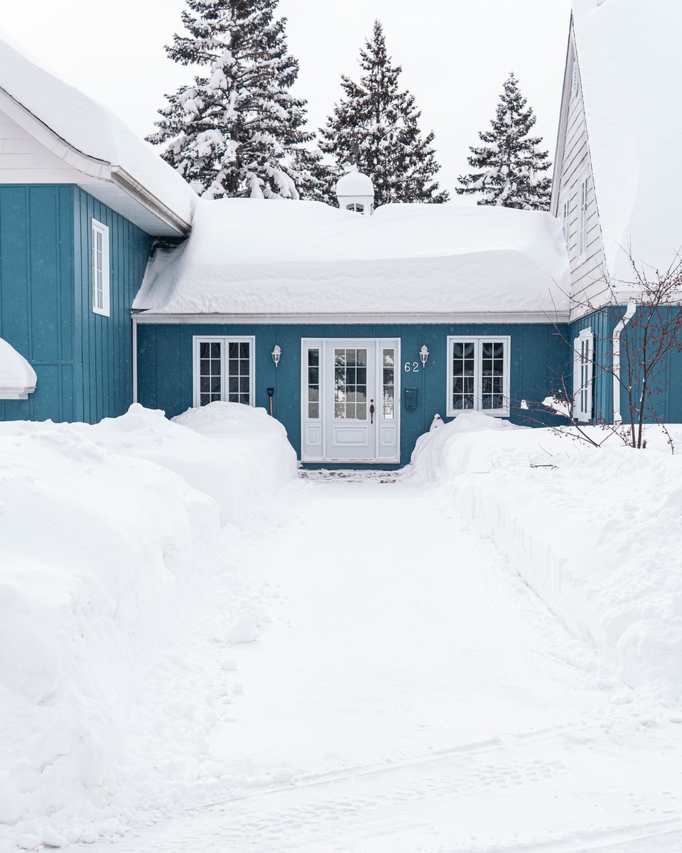 white wooden house on snow covered ground